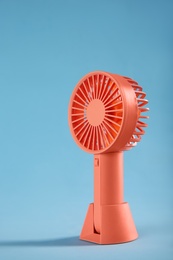 Photo of Modern electric fan on light blue background