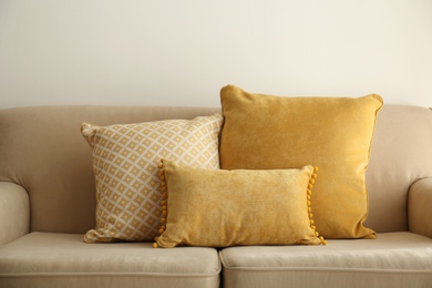 Three pillows on sofa near wall in room. Interior design