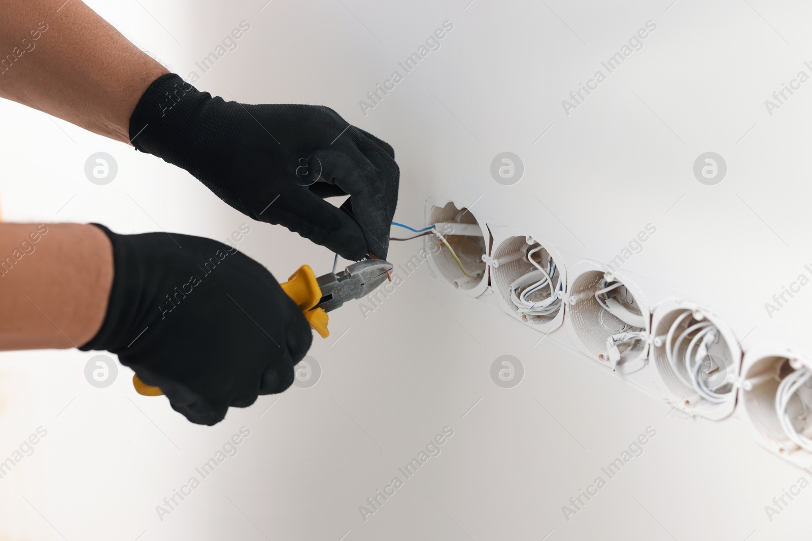 Photo of Handyman installing sockets in white wall, closeup