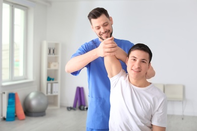 Physiotherapist working with male patient in clinic