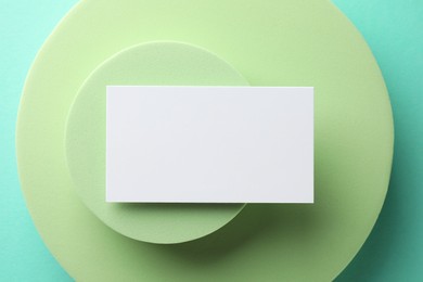 Empty business card and decorative elements on light blue background, top view. Mockup for design