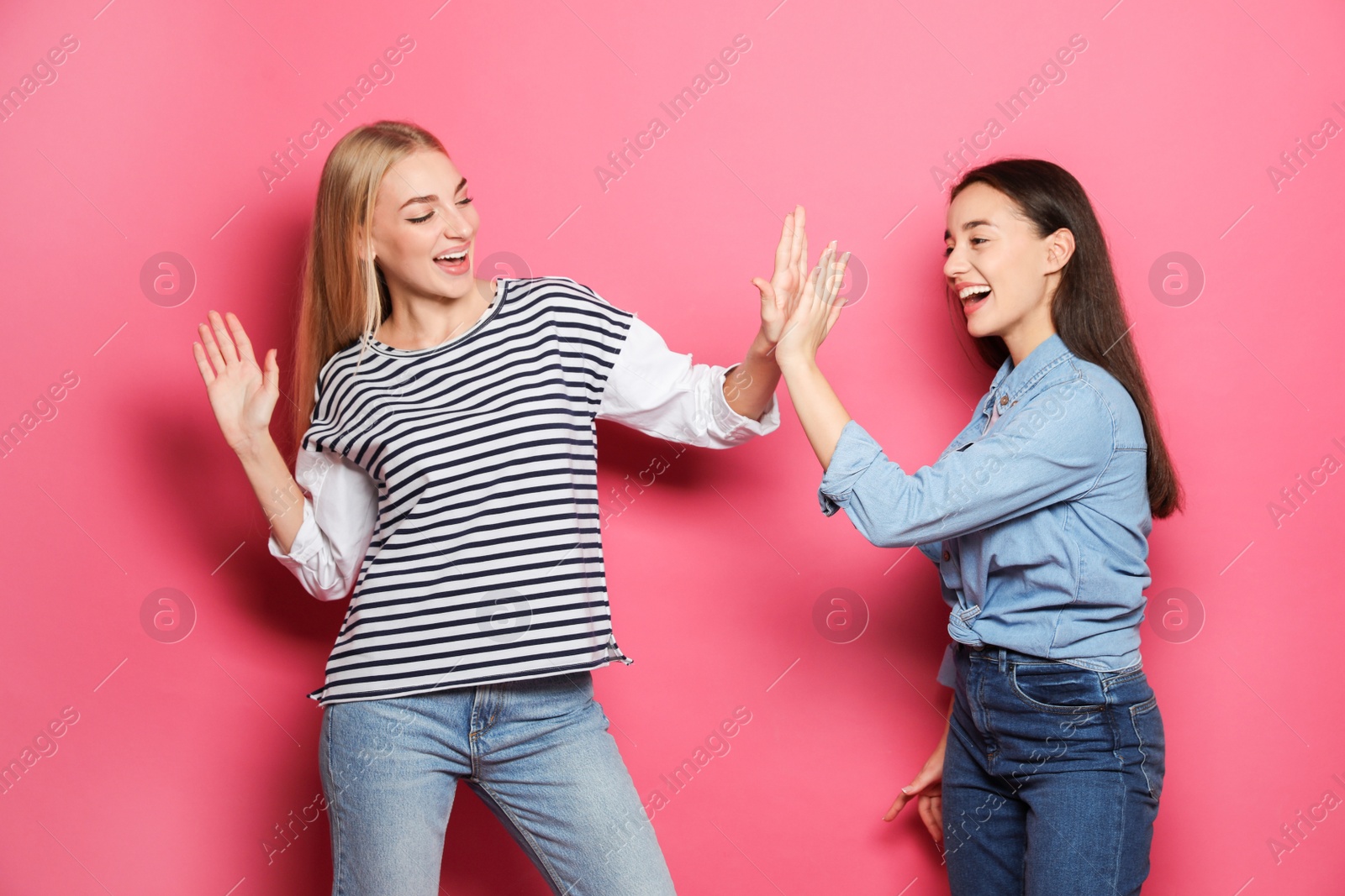 Photo of Young women celebrating victory against color background