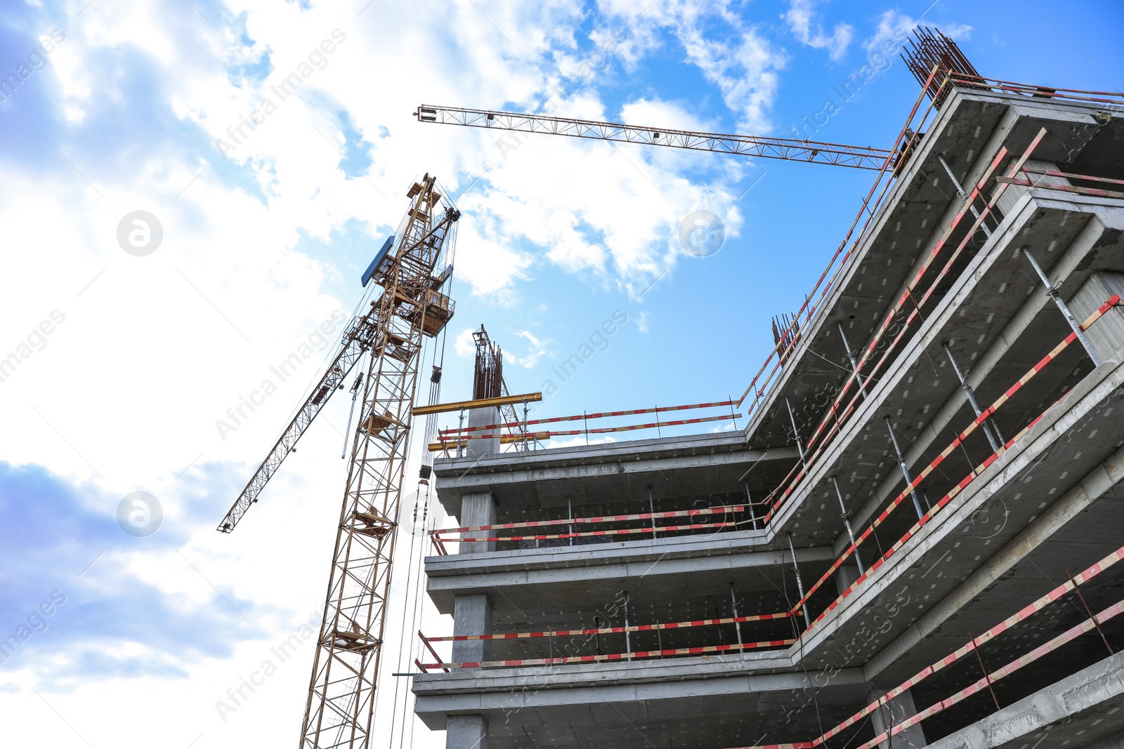 Photo of Unfinished building against blue sky. Construction safety rules