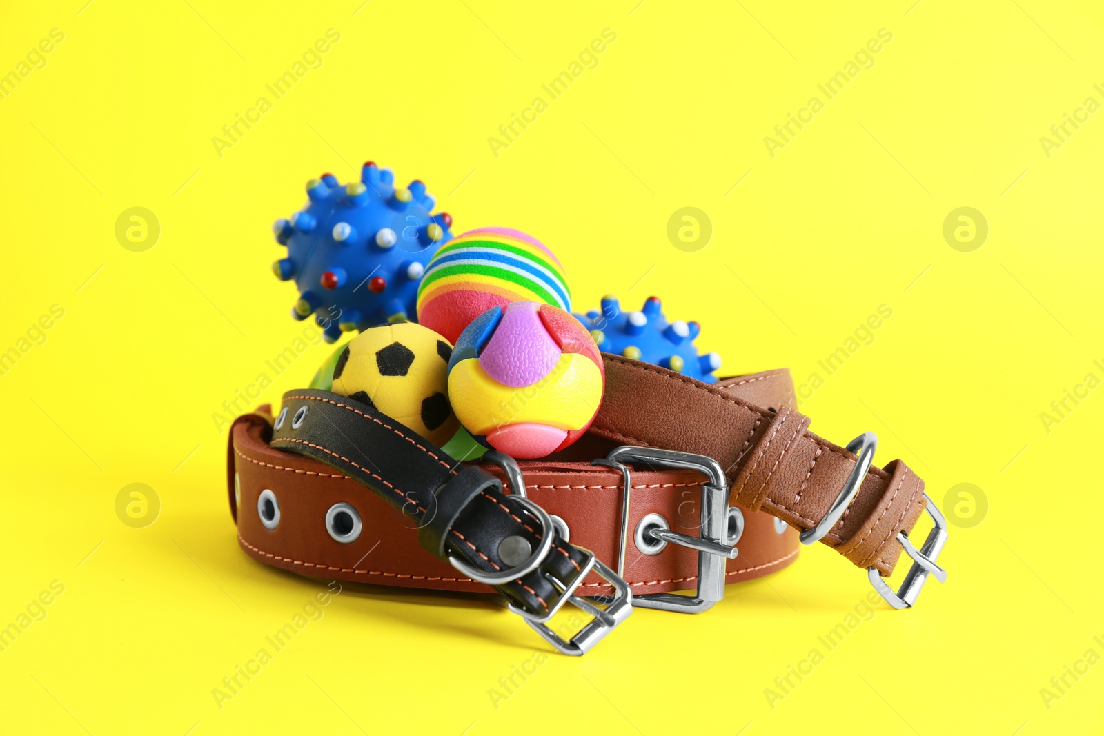 Photo of Pet toys and collars on yellow background