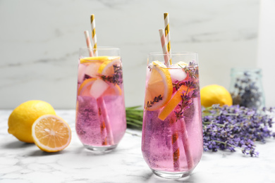 Photo of Fresh delicious lemonade with lavender and straws on white marble table