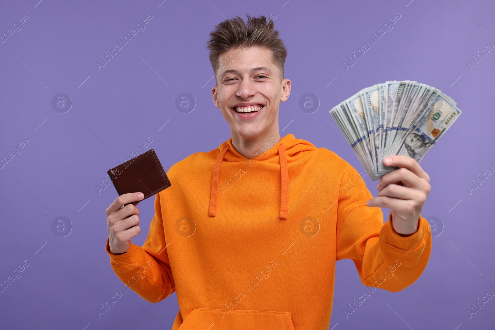 Photo of Happy man with money and wallet on purple background