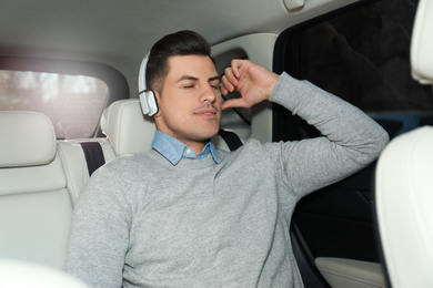 Photo of Handsome man listening to audiobook in car