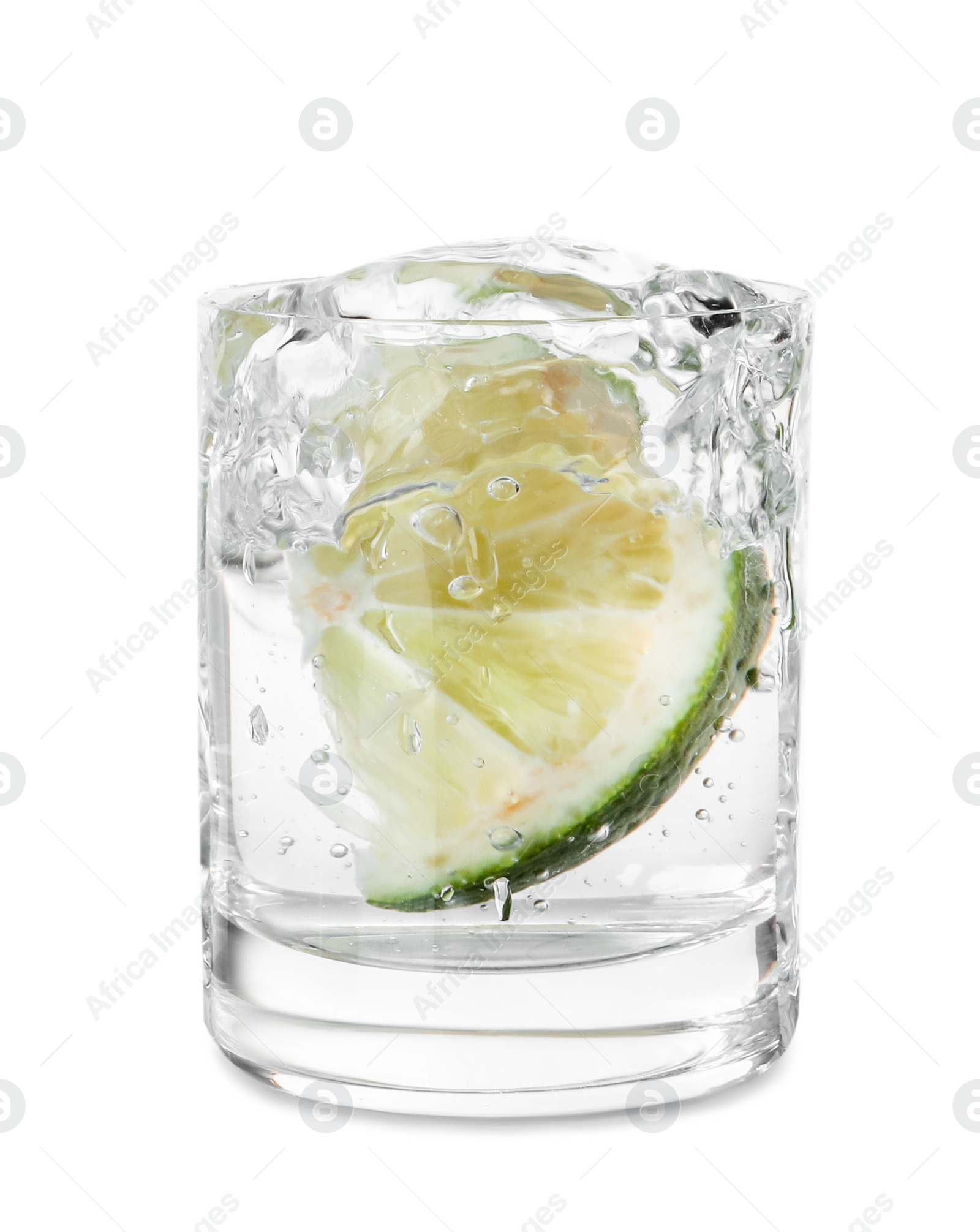 Photo of Vodka splashing out of shot glass with lime on white background