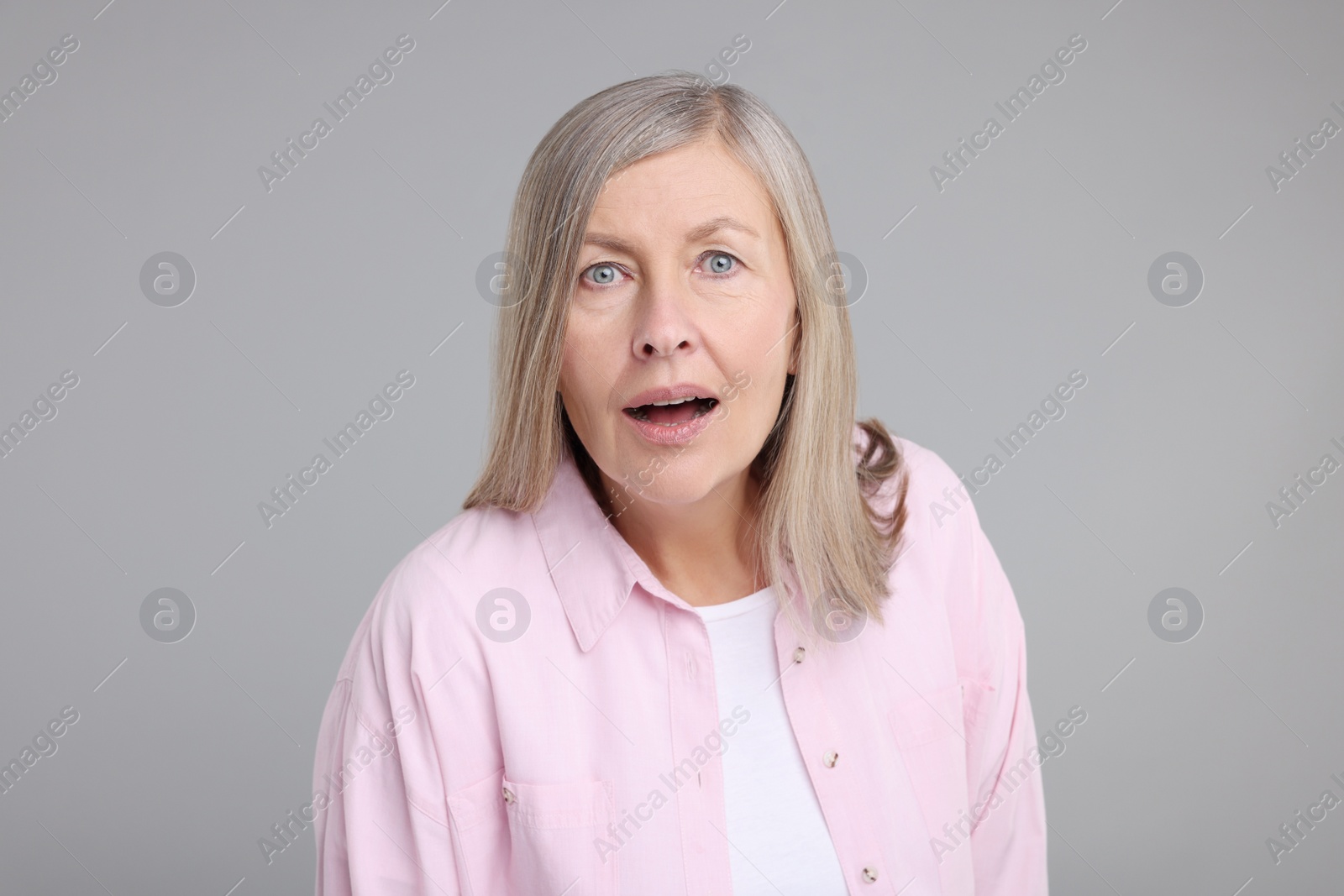 Photo of Portrait of surprised senior woman on grey background