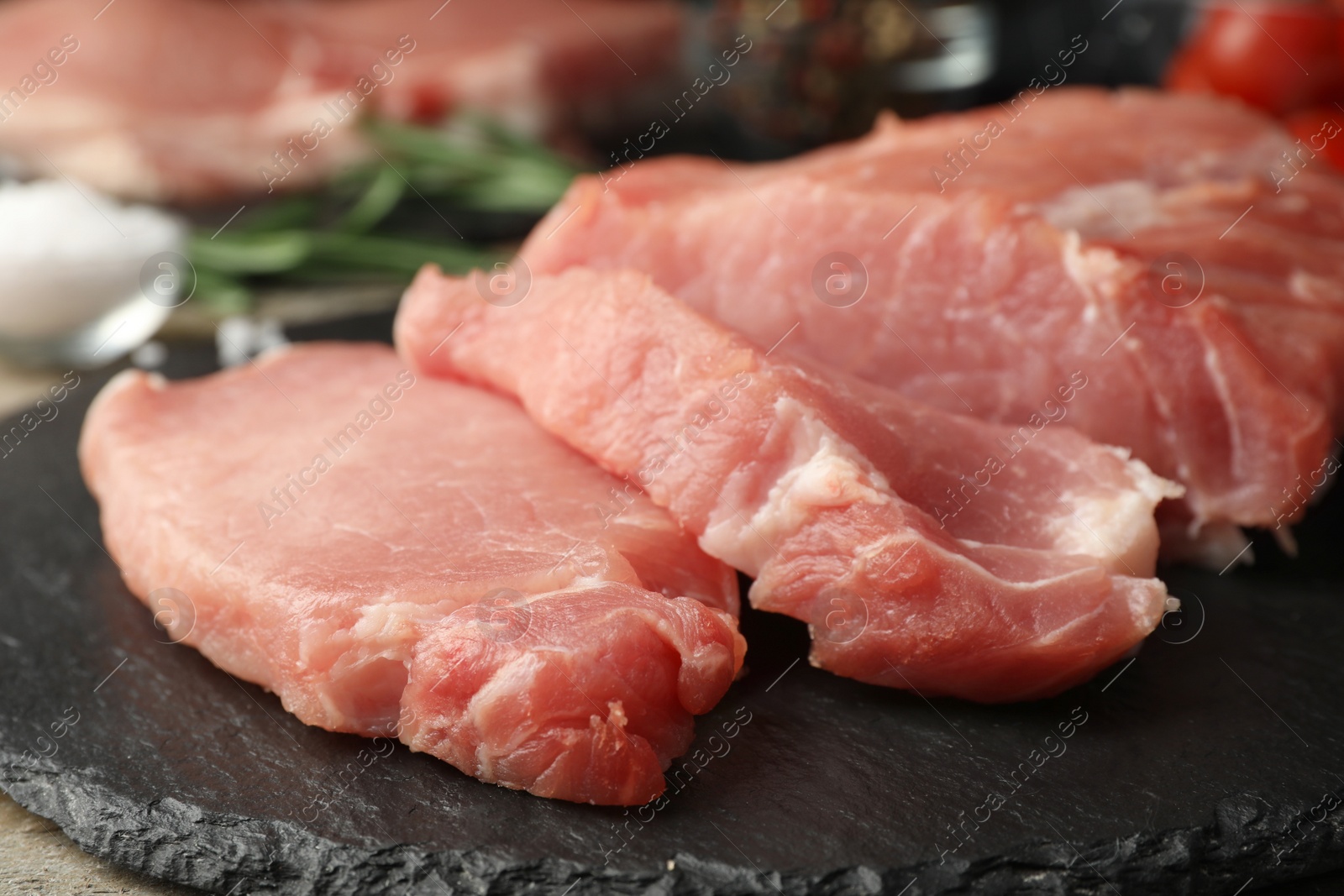 Photo of Fresh raw cut meat on slate plate, closeup