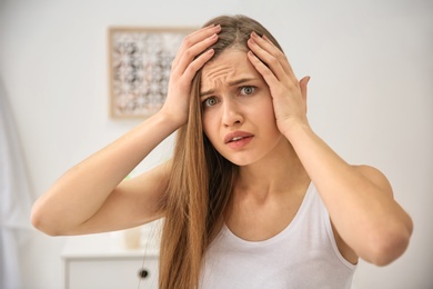 Photo of Young woman with hair loss problem indoors
