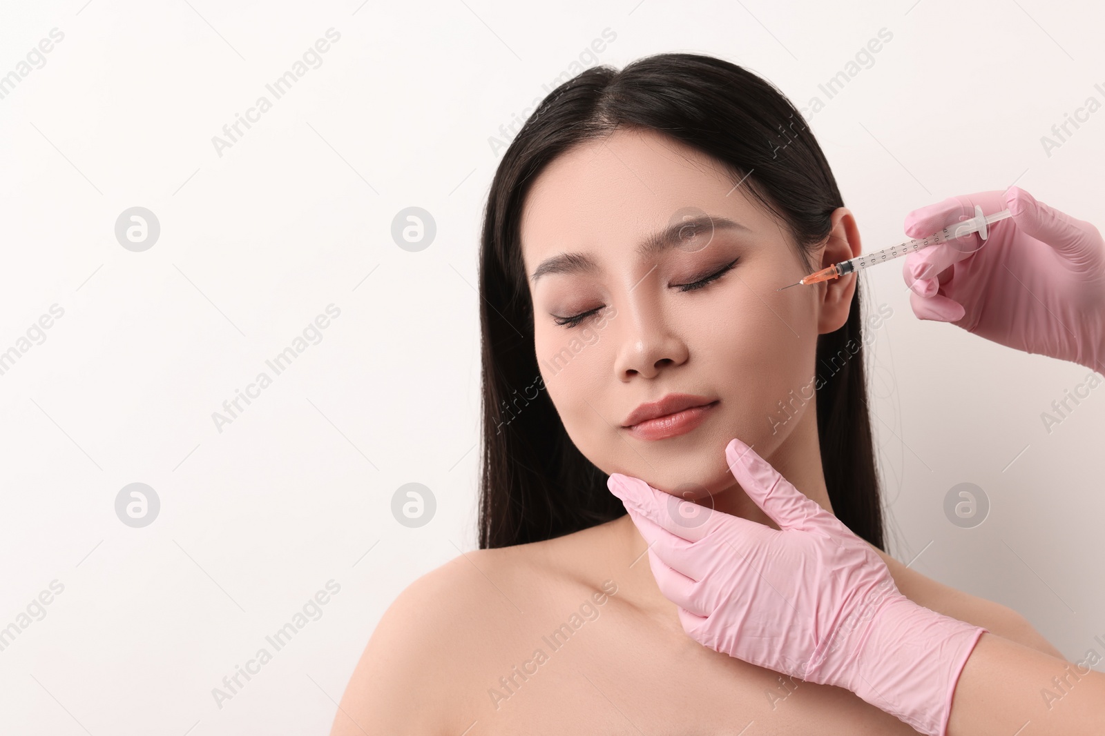Photo of Woman getting facial injection on white background