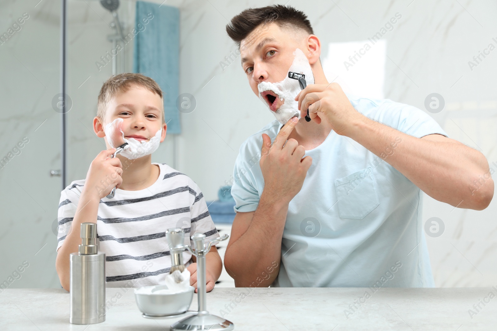 Photo of Dad shaving and son imitating him in bathroom