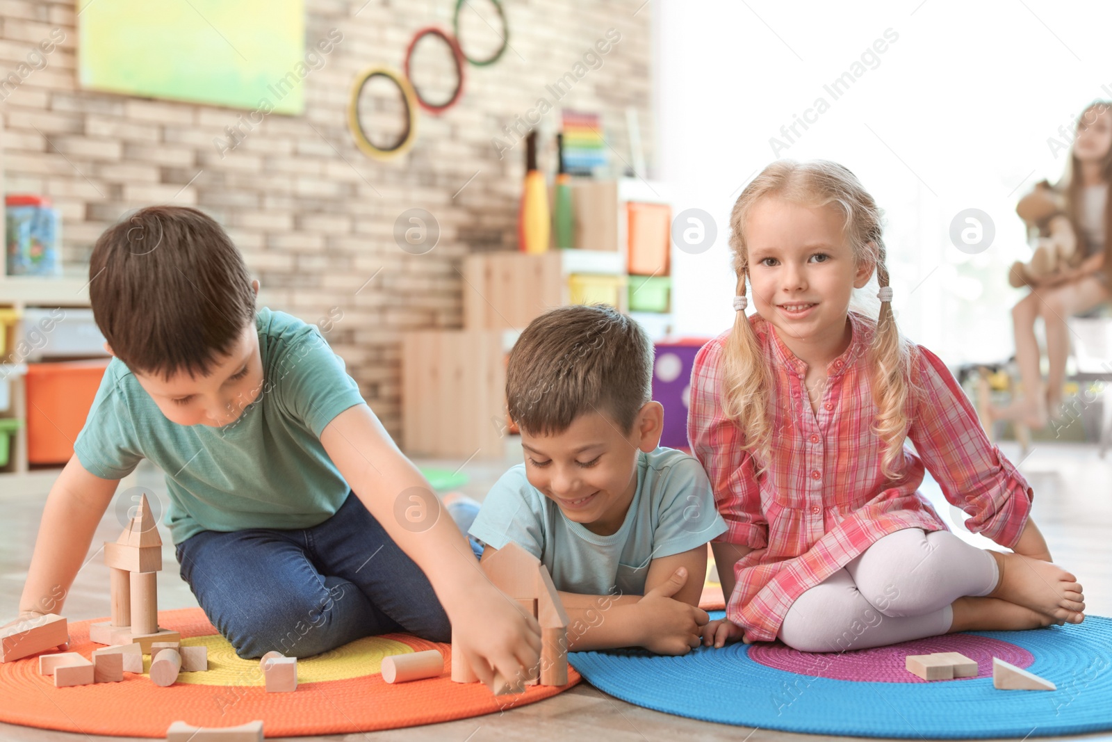 Photo of Cute little children playing with wooden blocks indoors