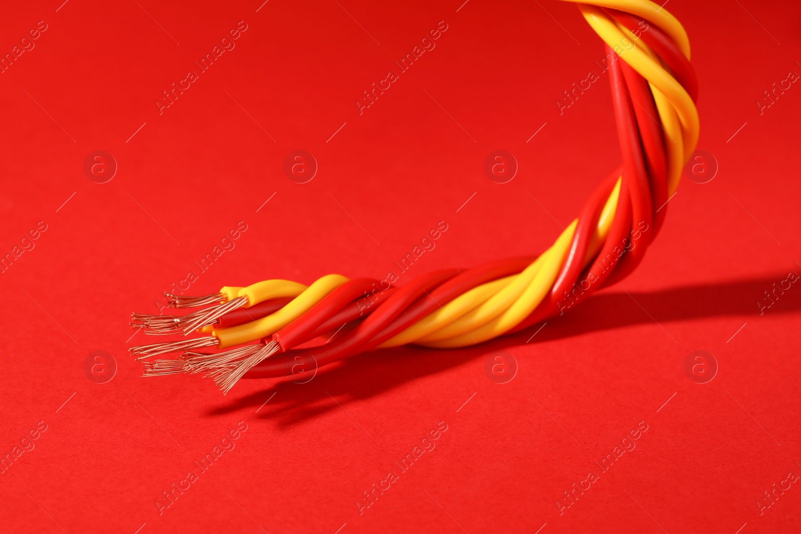 Photo of Electrical wires on red background, closeup view