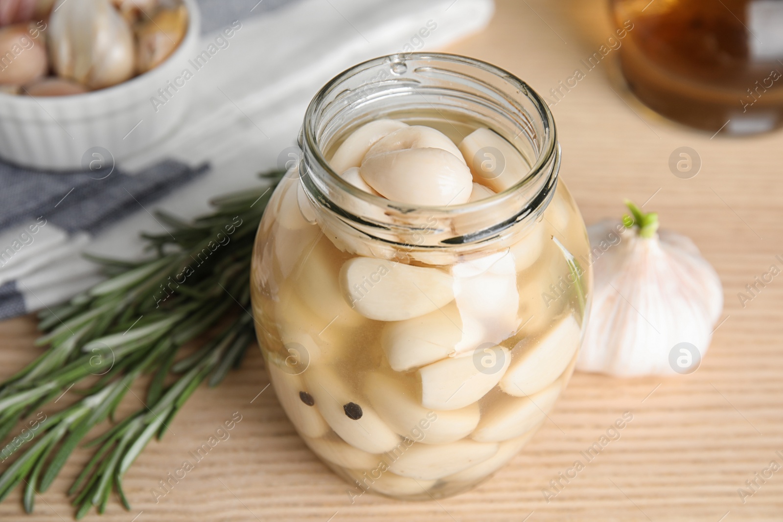 Photo of Composition with jar of pickled garlic on wooden table