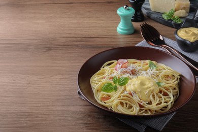 Photo of Delicious spaghetti with cheese sauce and meat on wooden table, space for text