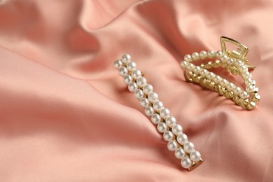 Photo of Elegant hair clips with pearls on pink silk