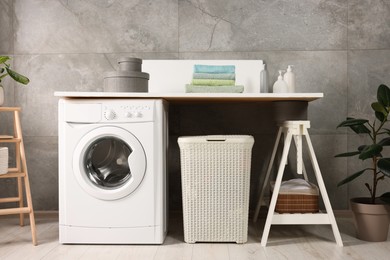 Photo of Stylish laundry room with modern washing machine. Interior design