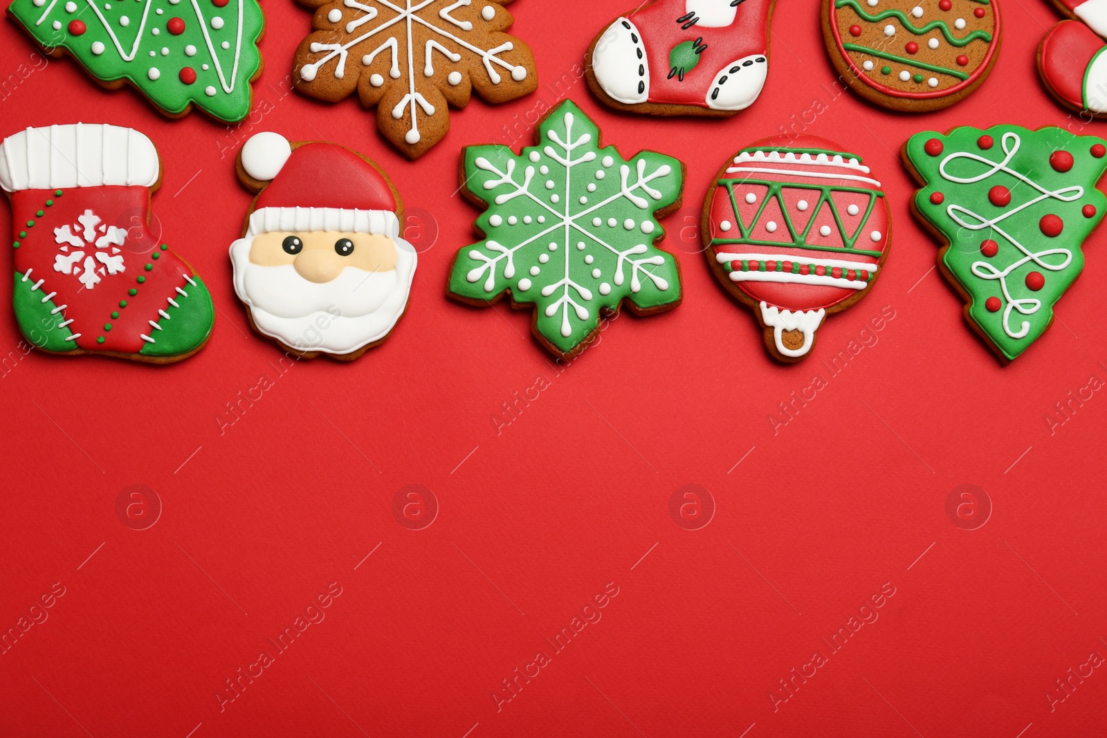 Photo of Different tasty Christmas cookies on red background, flat lay. Space for text