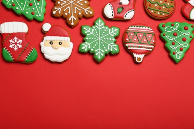 Different tasty Christmas cookies on red background, flat lay. Space for text