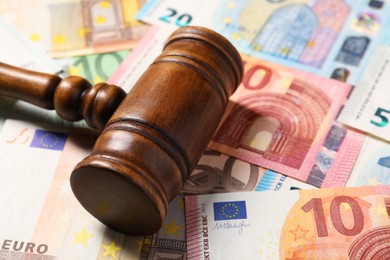 Tax law. Wooden gavel on euro banknotes, closeup