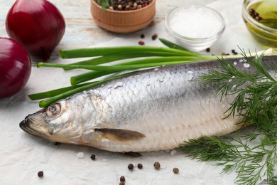 Photo of Delicious salted herring and ingredients on wooden table, closeup