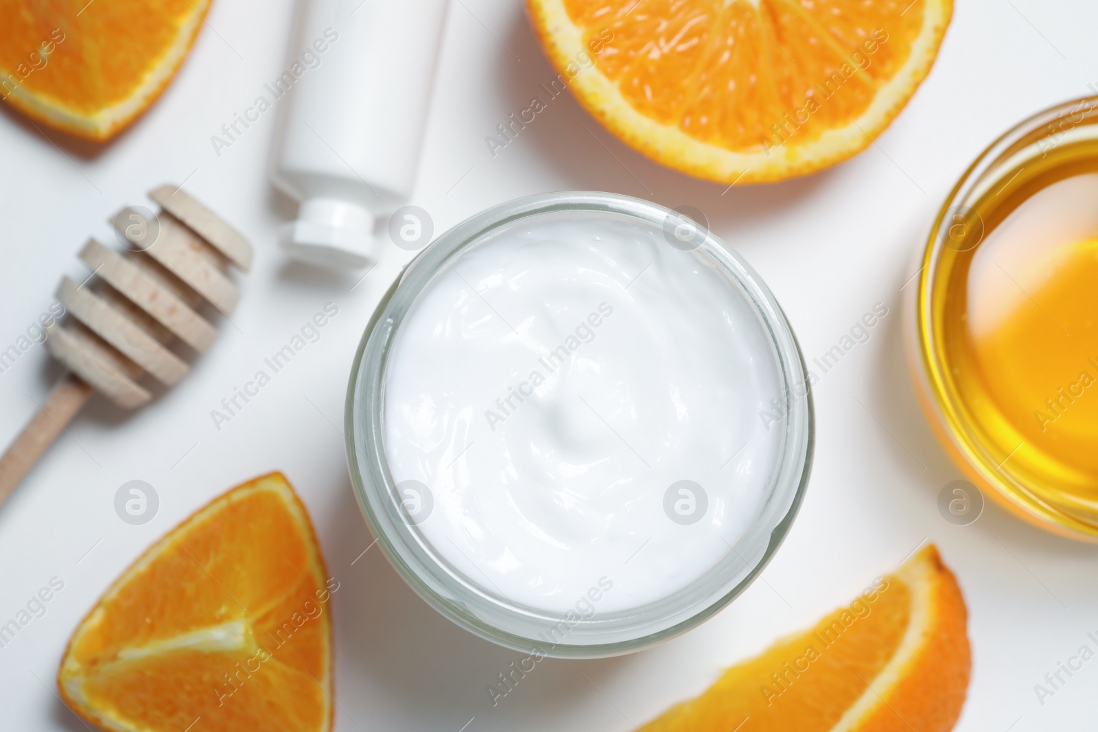 Photo of Jar of hand cream, orange and honey on white background, flat lay