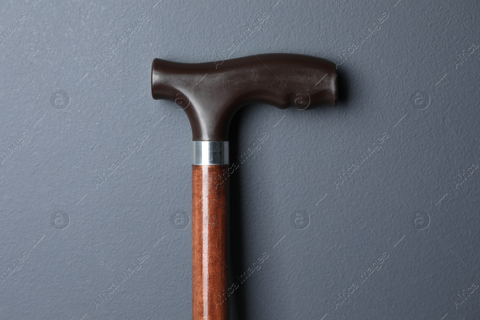 Photo of Elegant walking cane on grey background, closeup