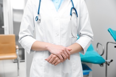 Photo of Young gynecologist in white coat at workplace, closeup