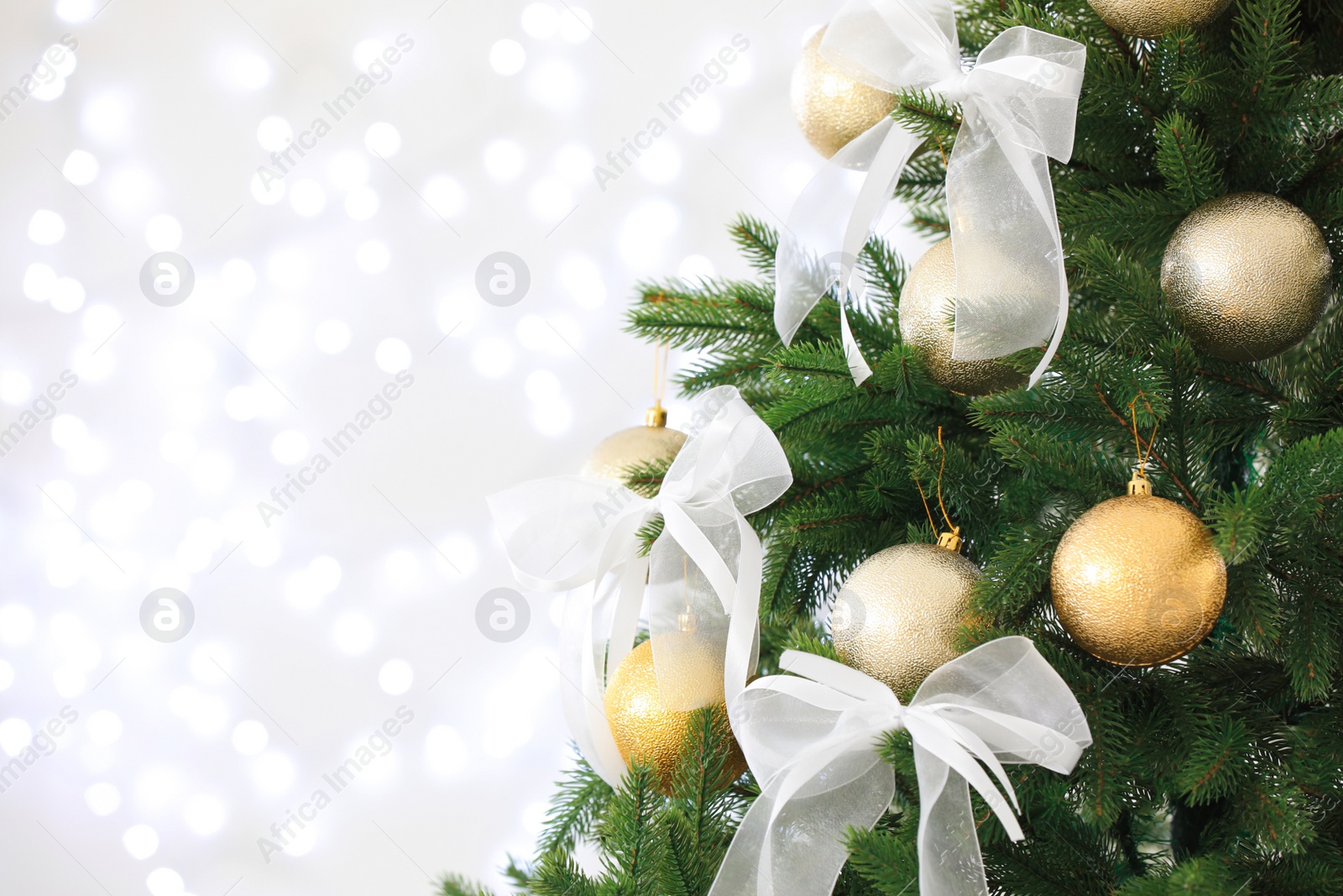 Photo of Beautiful decorated Christmas tree against blurred lights, closeup with space for text. Bokeh effect