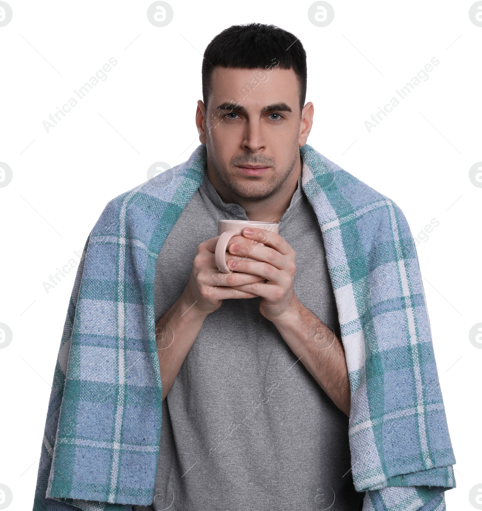 Photo of Man wrapped in blanket with cup of hot drink suffering from cold on white background