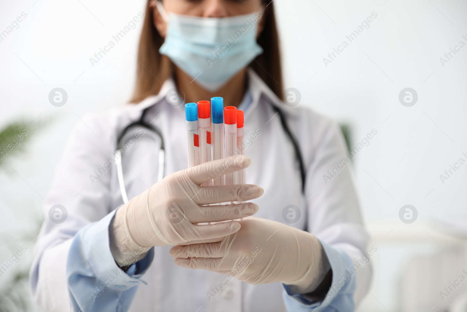 Photo of Doctor holding tubes with cotton swabs for DNA test in clinic, closeup