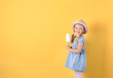 Cute little girl with cotton candy on color background. Space for text