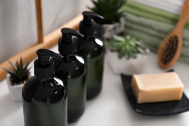 Soap dispensers on countertop in bathroom, closeup. Space for text