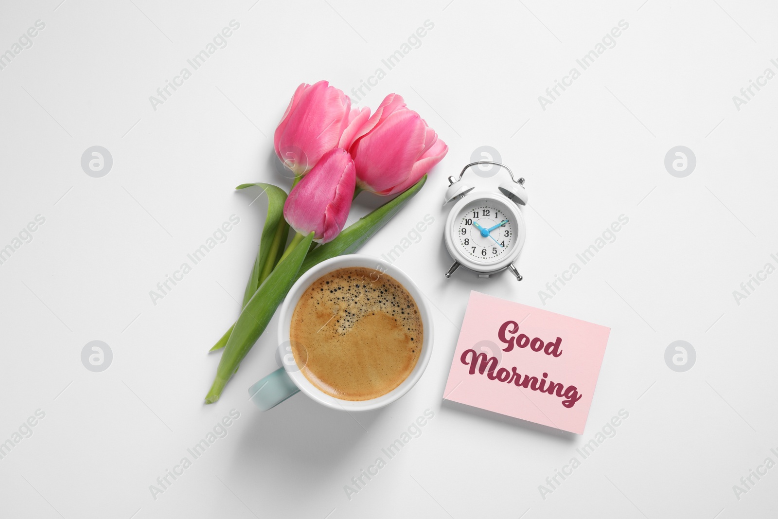 Image of Beautiful tulips, cup of coffee, alarm clock and card with text Good Morning on white background, flat lay