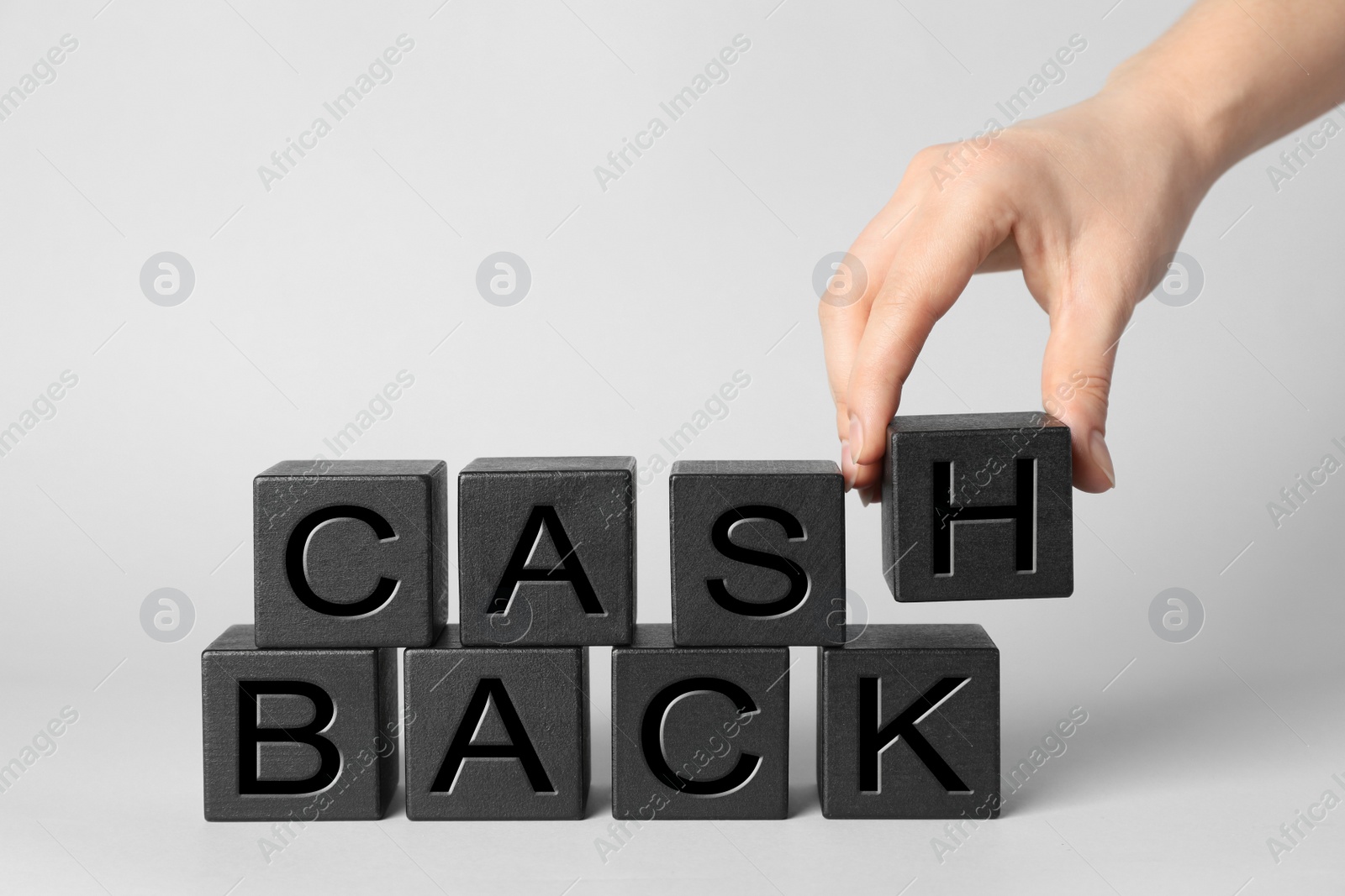 Photo of Woman making phrase Cashback with cubes on white background, closeup