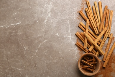 Photo of Aromatic cinnamon sticks on grey table, flat lay. Space for text
