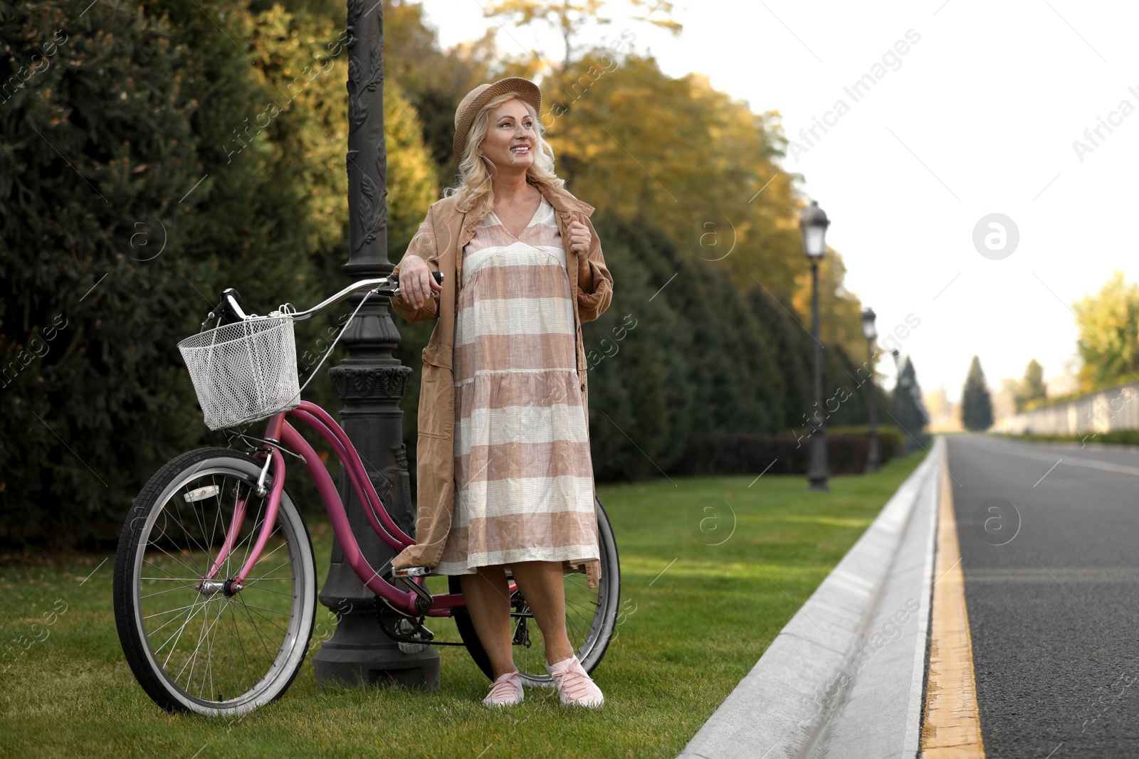 Photo of Mature woman with bicycle outdoors. Active lifestyle