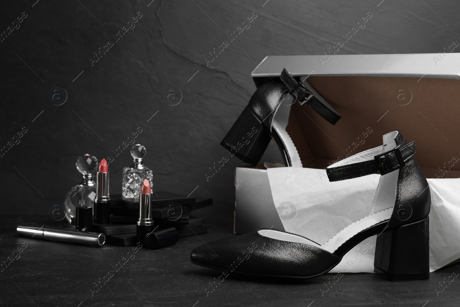 Photo of Composition with stylish female shoes on black stone table