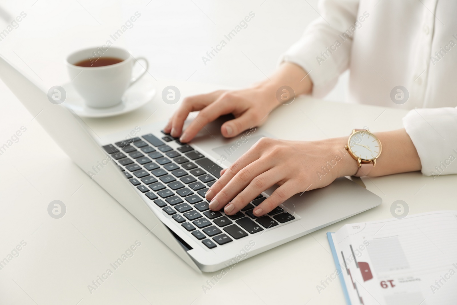 Photo of Young businesswoman using laptop at table in office, closeup