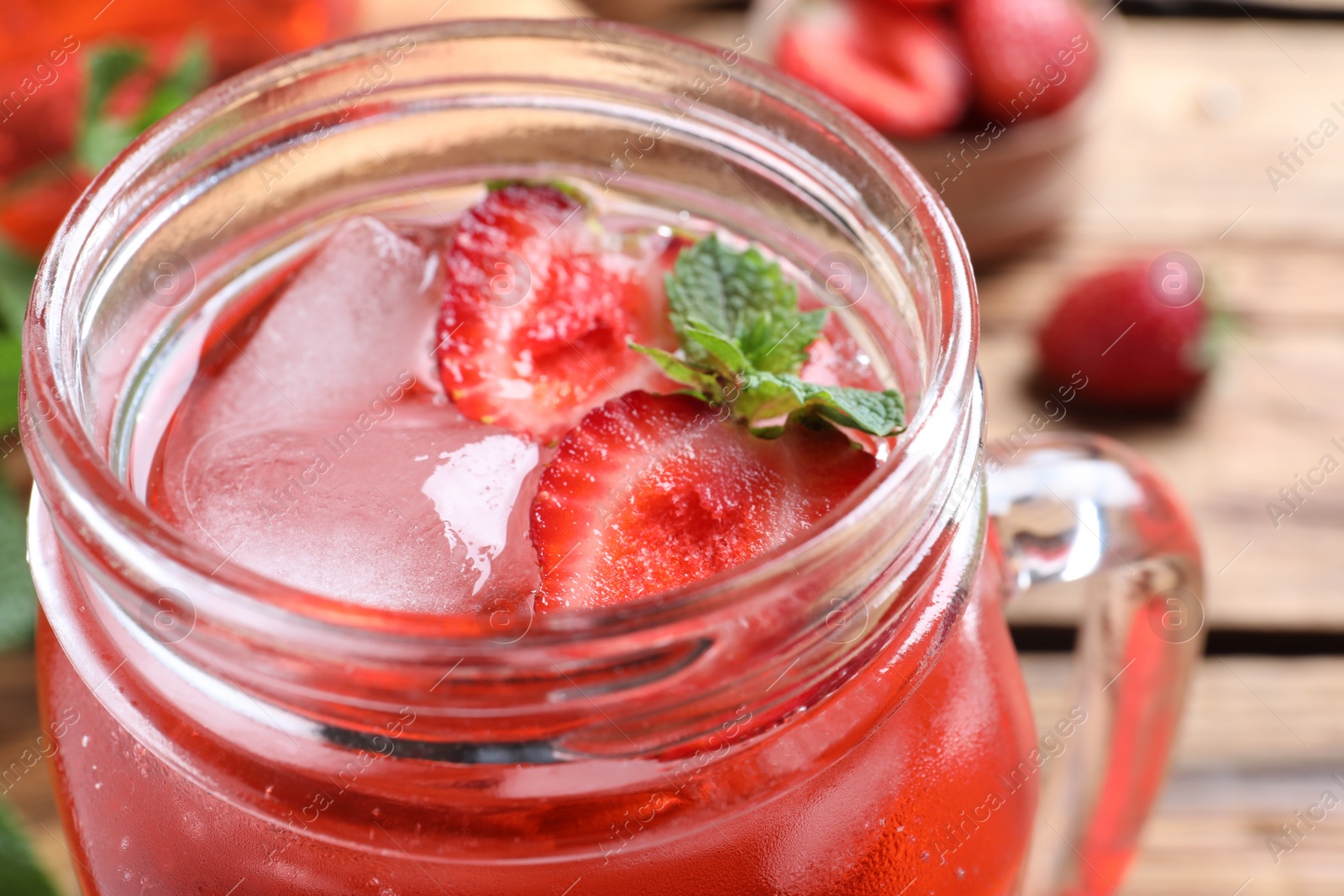 Photo of Delicious strawberry lemonade made with soda water in mason jar, closeup