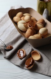 Photo of Delicious walnut shaped cookies with condensed milk on white wooden table