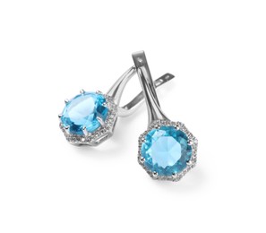 Photo of Elegant silver earrings with light blue gemstones isolated on white. Luxury jewelry