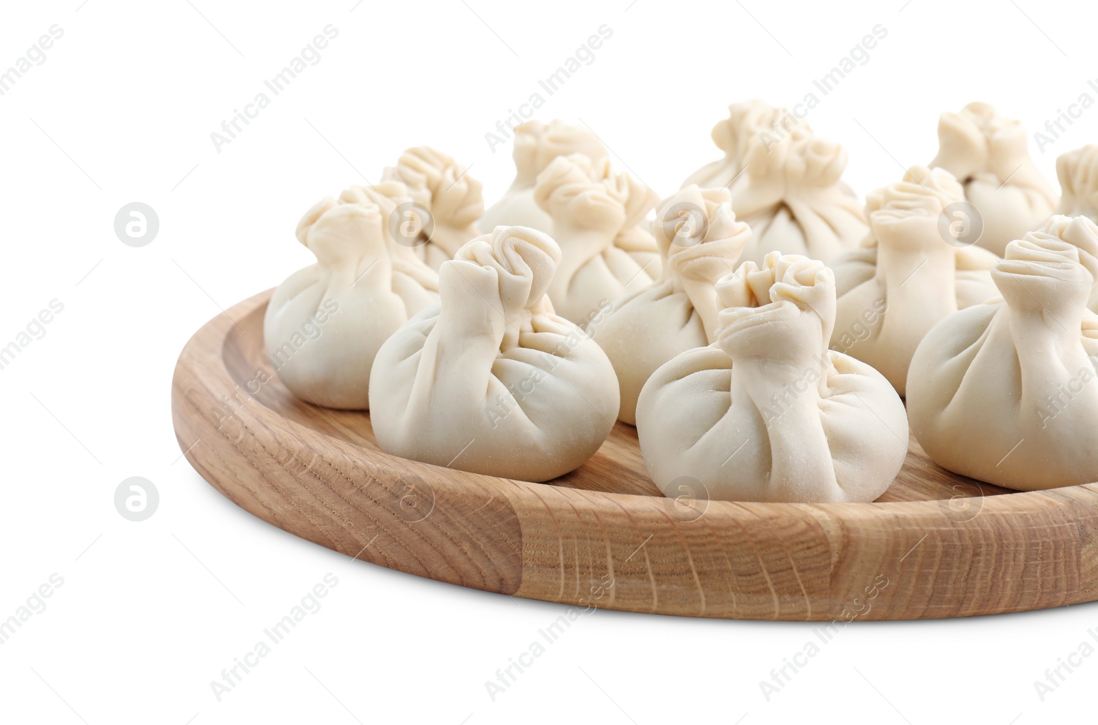 Photo of Wooden board with uncooked khinkali (dumplings) isolated on white. Georgian cuisine