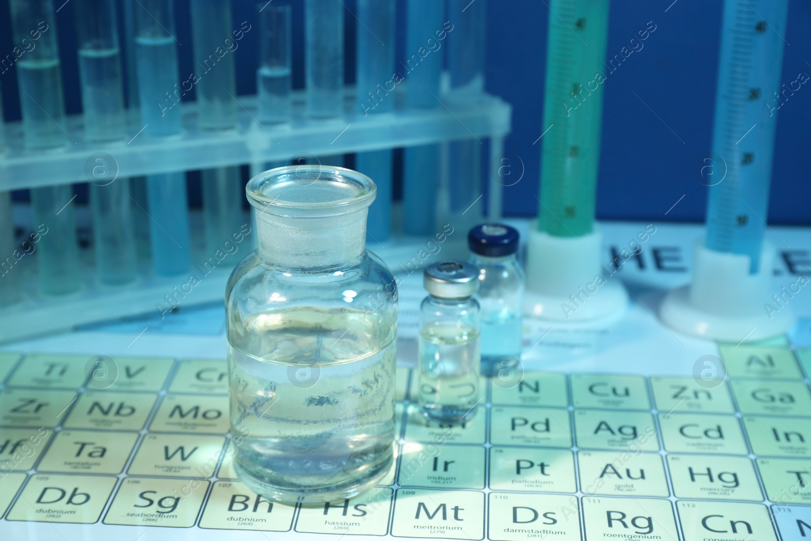 Photo of Bottles on periodic table of chemical elements, closeup