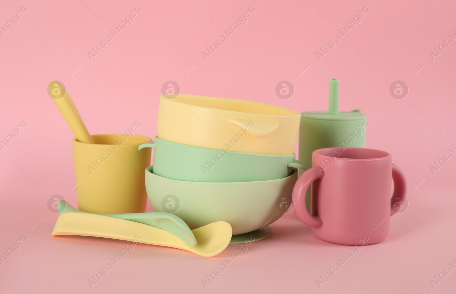 Photo of Set of plastic dishware on pink background. Serving baby food
