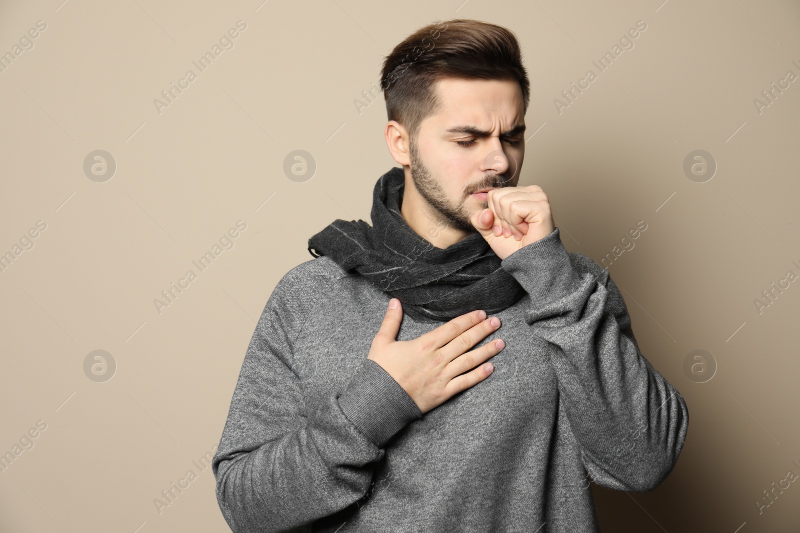 Photo of Handsome young man coughing against color background