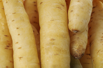Photo of Fresh raw white carrots as background, closeup