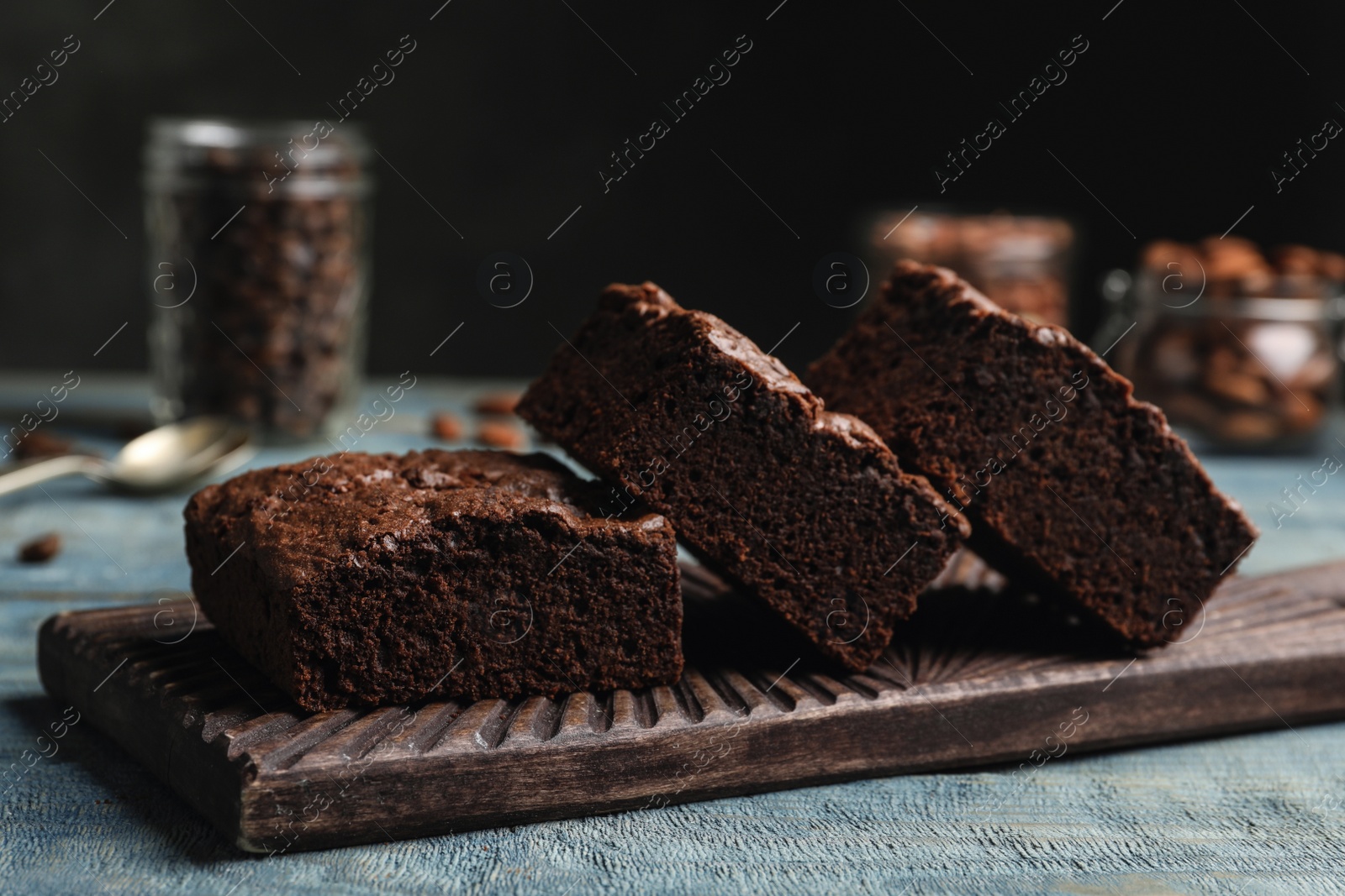 Photo of Wooden board with fresh brownies on table. Delicious chocolate pie